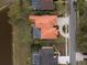 Aerial view of a home with a tile roof, screened-in pool, and well-kept landscaping at 3830 Moreno Dr, Palm Harbor, FL 34685