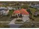 An aerial shot shows a home with a red tile roof, private pool, and lush landscaping at 3830 Moreno Dr, Palm Harbor, FL 34685