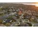 Aerial view of a home with a red roof, a screened-in pool, and a lake view at 3830 Moreno Dr, Palm Harbor, FL 34685