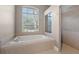 Bathroom with a large window, soaking tub, tile floors, and a tiled walk-in shower at 3830 Moreno Dr, Palm Harbor, FL 34685