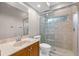 Well-lit bathroom with glass shower door and a wooden vanity with a marble countertop at 3830 Moreno Dr, Palm Harbor, FL 34685
