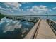 Community pier with clear blue sky reflecting on the water at 3830 Moreno Dr, Palm Harbor, FL 34685