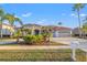 Beautiful home featuring a red tile roof, manicured landscaping, and a spacious three-car garage at 3830 Moreno Dr, Palm Harbor, FL 34685