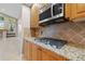 Gas cooktop and stainless microwave above, set in granite countertops and wood cabinetry at 3830 Moreno Dr, Palm Harbor, FL 34685