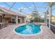A beautiful outdoor pool with spa in a screened enclosure and brick paver patio for relaxing and entertaining at 3830 Moreno Dr, Palm Harbor, FL 34685