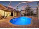 Beautiful screened-in pool with brick patio and a connected spa, perfect for outdoor relaxation at 3830 Moreno Dr, Palm Harbor, FL 34685