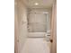 Bright bathroom features white tile flooring, a shower-tub combo with sliding glass doors and a toilet at 4801 Osprey S Dr # 209, St Petersburg, FL 33711