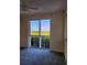 A bright bedroom with carpet flooring, a ceiling fan, and sliding glass doors lead to a scenic balcony view at 4801 Osprey S Dr # 209, St Petersburg, FL 33711