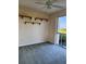 Bright bedroom features carpet flooring, a fan, three shelves, and a sliding glass door to the balcony at 4801 Osprey S Dr # 209, St Petersburg, FL 33711
