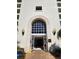 Front entrance of building featuring an arched doorway and sconce lighting at 4801 Osprey S Dr # 209, St Petersburg, FL 33711