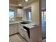 Kitchen with white cabinets and countertops, featuring a stainless steel sink and open dishwasher at 4801 Osprey S Dr # 209, St Petersburg, FL 33711
