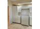 Bright kitchen with white cabinets and appliances, including a refrigerator and tall pantry at 4801 Osprey S Dr # 209, St Petersburg, FL 33711