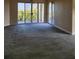 Spacious carpeted living room featuring large sliding doors to balcony with a view at 4801 Osprey S Dr # 209, St Petersburg, FL 33711