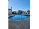 Community pool with lounge chairs and beautiful lakeside views under a clear sky at 4801 Osprey S Dr # 209, St Petersburg, FL 33711