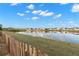 Scenic backyard view with a tranquil pond reflecting the sky and neighboring homes at 5236 Clover Mist Dr, Apollo Beach, FL 33572