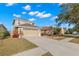 Spacious front exterior of a two-story home featuring a well manicured lawn, tasteful landscaping, and a two-car garage at 5236 Clover Mist Dr, Apollo Beach, FL 33572