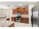 Bright kitchen features stainless steel appliances, brown cabinets, and tile backsplash at 5236 Clover Mist Dr, Apollo Beach, FL 33572