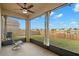 Screened patio area with a fan overlooking the backyard and pond at 5236 Clover Mist Dr, Apollo Beach, FL 33572