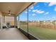 Screened patio area with a fan overlooking the backyard and pond at 5236 Clover Mist Dr, Apollo Beach, FL 33572