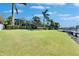 Expansive green backyard featuring tropical landscaping and waterfront views at 5326 Loon Nest Ct, Apollo Beach, FL 33572