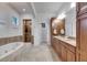 Bright bathroom featuring a soaking tub and shower with tile surround, and granite countertops at 5326 Loon Nest Ct, Apollo Beach, FL 33572
