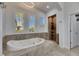 Well-lit bathroom with soaking tub, tiled shower, and plantation shutters at 5326 Loon Nest Ct, Apollo Beach, FL 33572