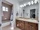 Bathroom featuring double sink vanity, a shower with tile surround, and large vanity mirror at 5326 Loon Nest Ct, Apollo Beach, FL 33572