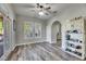 Bedroom with neutral walls, wood-look floors, ceiling fan, and storage shelf at 5326 Loon Nest Ct, Apollo Beach, FL 33572