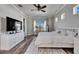 Bright bedroom with a large bed, ceiling fan, wood floors, and natural light streaming through the windows at 5326 Loon Nest Ct, Apollo Beach, FL 33572