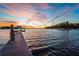 Wooden dock at the end of a lake during sunset with a beautiful display of sky colors at 5326 Loon Nest Ct, Apollo Beach, FL 33572