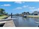 Wide view of a private wooden dock featuring boat lift on a waterfront property under a sunny blue sky at 5326 Loon Nest Ct, Apollo Beach, FL 33572