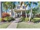 Charming two-story home featuring lush landscaping, mature palms, and a welcoming front porch at 5326 Loon Nest Ct, Apollo Beach, FL 33572