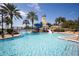 A beautiful community pool with a lighthouse water slide feature with a blue sky backdrop and palm trees at 5326 Loon Nest Ct, Apollo Beach, FL 33572