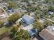Aerial view of a two-story home with a metal roof, a paver driveway, and a detached garage at 6131 Central Ave, New Port Richey, FL 34653