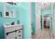 Stylish blue bathroom featuring a vanity with a sliding barn door, and a shower and laundry area at 6131 Central Ave, New Port Richey, FL 34653