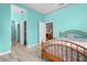 Stylish blue bedroom with light wood floors, an exposed bed frame, and access to a hallway at 6131 Central Ave, New Port Richey, FL 34653