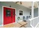 Inviting covered front porch featuring a vibrant red front door and comfortable seating area at 6131 Central Ave, New Port Richey, FL 34653