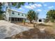 Charming two-story home with lush landscaping, mature palm trees, and a welcoming front yard at 6131 Central Ave, New Port Richey, FL 34653