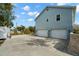Exterior side view showcasing a two-car garage and a well-maintained landscaped yard at 6131 Central Ave, New Port Richey, FL 34653