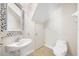 Bright powder room featuring pedestal sink with decorative mirror and tile flooring at 6262 Maisie Rd, Zephyrhills, FL 33542