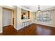 Dining area featuring hardwood floors, elegant lighting, breakfast bar, and a large window at 6262 Maisie Rd, Zephyrhills, FL 33542