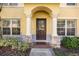 Charming home featuring a covered front door with decorative pillars and manicured landscaping at 6262 Maisie Rd, Zephyrhills, FL 33542