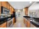 Well-equipped kitchen featuring stainless steel appliances, granite counters, and tile floors at 6262 Maisie Rd, Zephyrhills, FL 33542