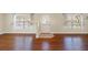 Living room featuring gleaming hardwood floors, large windows, and neutral paint colors at 6262 Maisie Rd, Zephyrhills, FL 33542