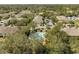 An aerial view of a community pool surrounded by green landscaping and various apartments at 6262 Maisie Rd, Zephyrhills, FL 33542