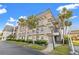 Well-maintained condo building with lush landscaping and palm trees under a bright blue sky at 716 Cordova Grn, Seminole, FL 33777
