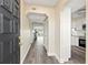 Inviting hallway with wood-look floors leading to a bright living area and modern kitchen at 716 Cordova Grn, Seminole, FL 33777
