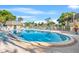 Community pool featuring inviting blue water, a bath house, lounge chairs, and well-maintained landscaping at 716 Cordova Grn, Seminole, FL 33777