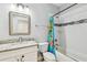 Well-lit bathroom featuring a tub with tiled walls, shower, and stylish vanity at 7403 S Obrien St, Tampa, FL 33616