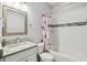 Well-lit bathroom featuring a white vanity with a marble countertop, a bathtub with white subway tile, and modern fixtures at 7403 S Obrien St, Tampa, FL 33616